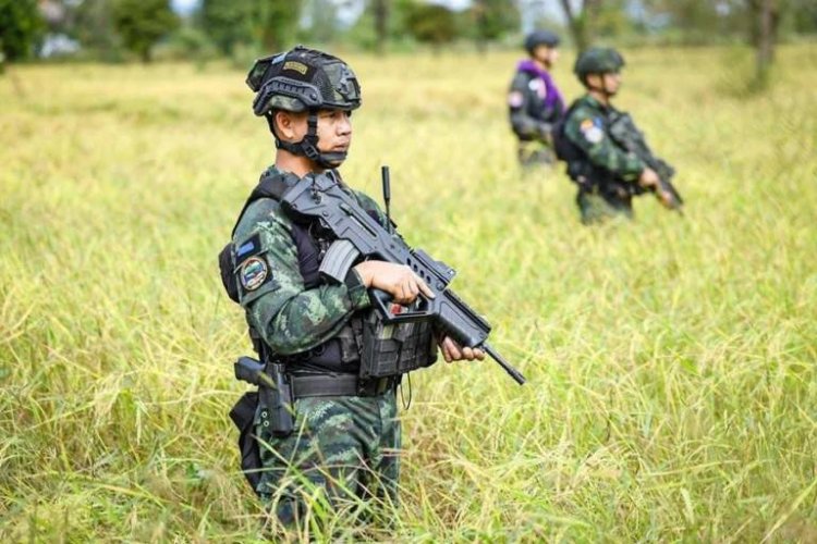 กำลังพลถือปืนอารักขาลงแขกช่วยเกษตรกรบ้านหนองหญ้าแก้วเกี่ยวข้าว